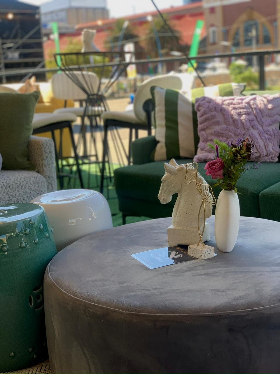 Corporate lounge with green velvet seating, statement vases, and curated accessories