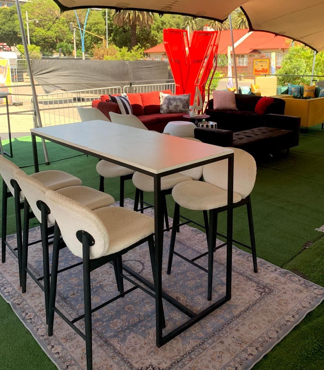 Corporate high-table setup with bouclé bar stools and a styled outdoor lounge