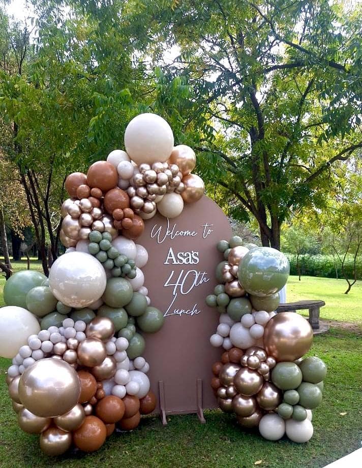 Sage, rust, and gold balloon arch for a 40th birthday garden lunch